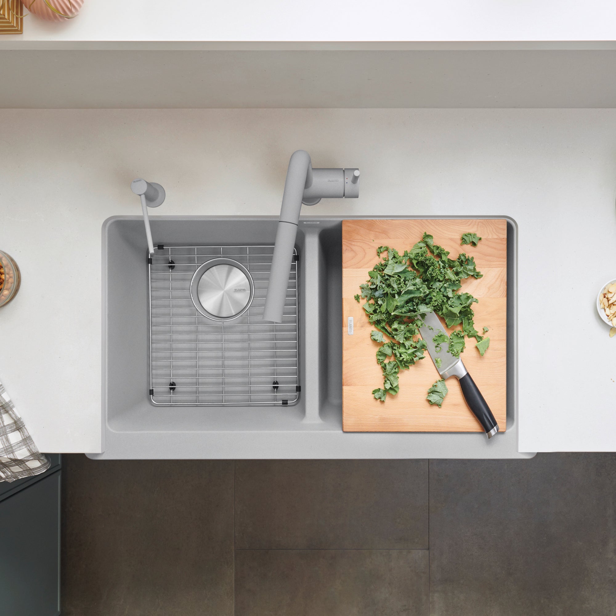 Stainless steel grid insert with circular center hole, positioned in left basin of double sink.