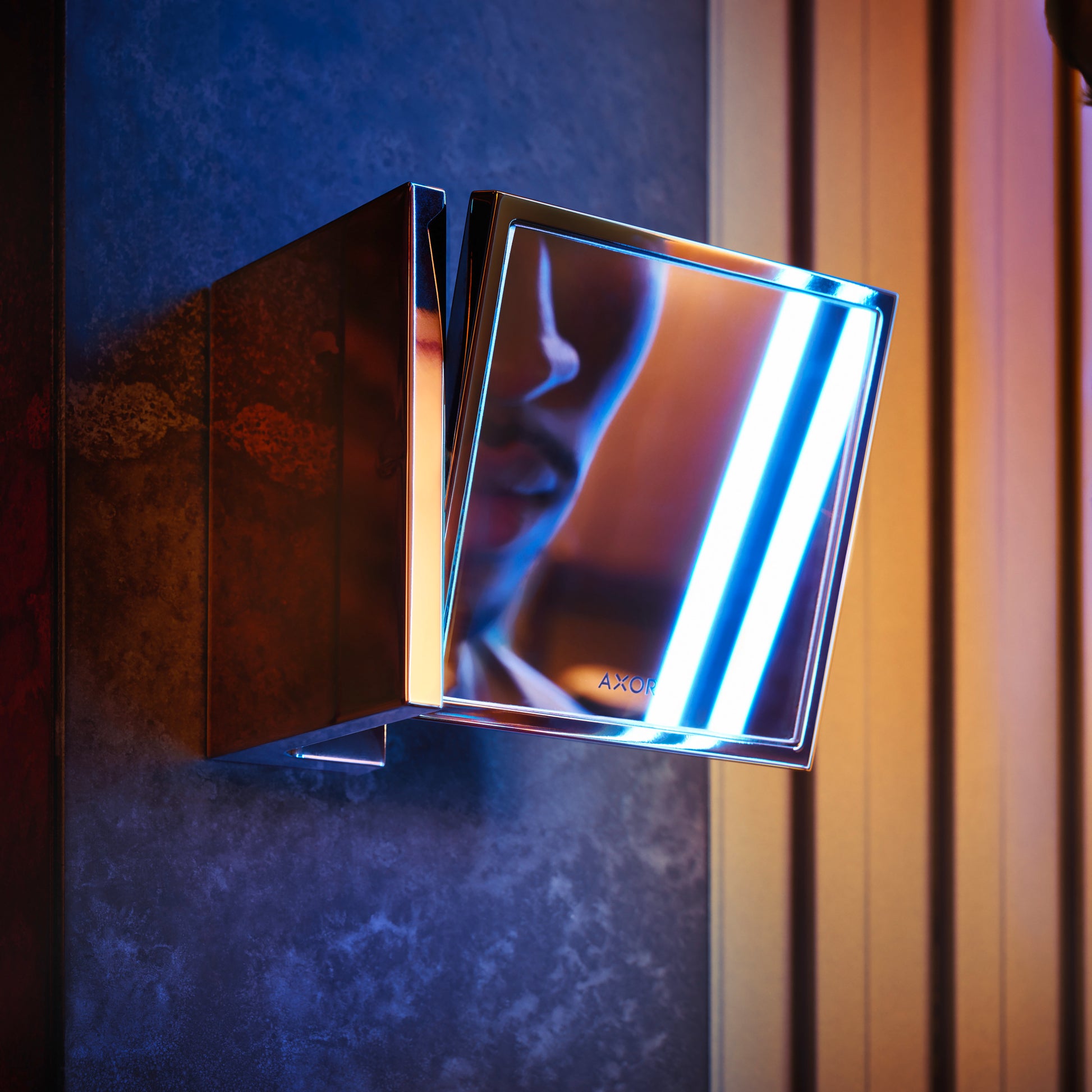 Rectangular brushed nickel shaving mirror with integrated LED lighting mounted on blue textured wall.