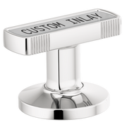 Chrome T-shaped faucet handle with vertical ribbed sides and custom inlay area on top, mounted on circular base.