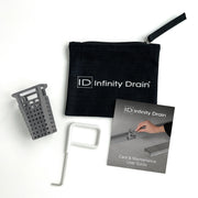 Black Infinity Drain maintenance kit containing gray perforated basket, white removal tool, care guide, and black carrying po