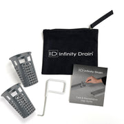 Black Infinity Drain maintenance kit containing two gray perforated baskets, white removal tool, care guide, and black carryi