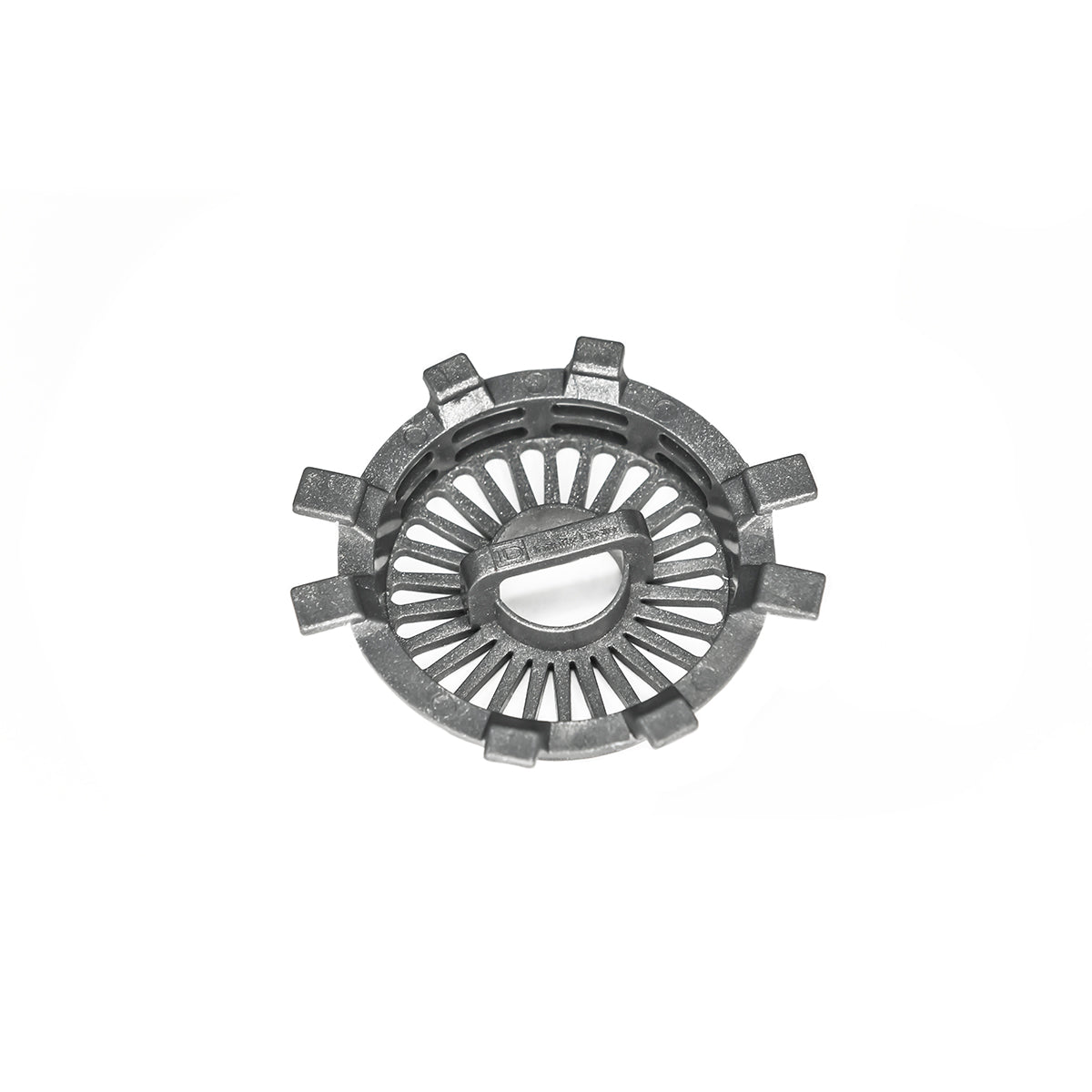 Round gray metal drain component with radial slot pattern and protruding tabs around outer edge.