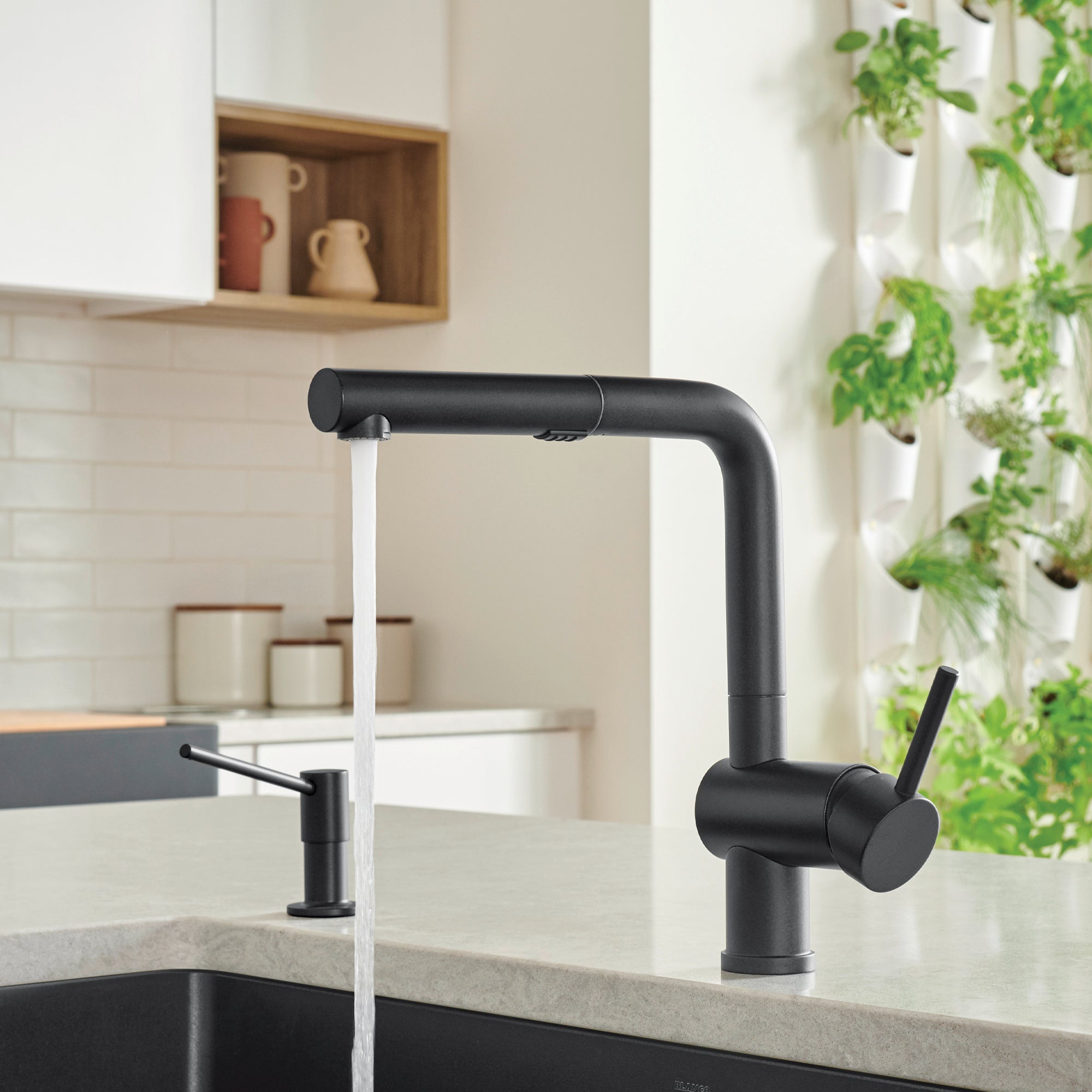 Coal black pull-out kitchen faucet with angled spout and side lever handle over sink.