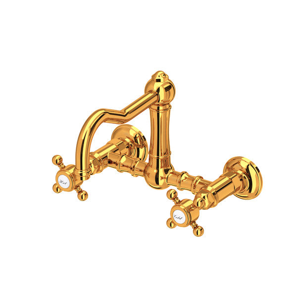 Wall-mounted bridge kitchen faucet with vertical column spout and cross handles in polished Italian brass.