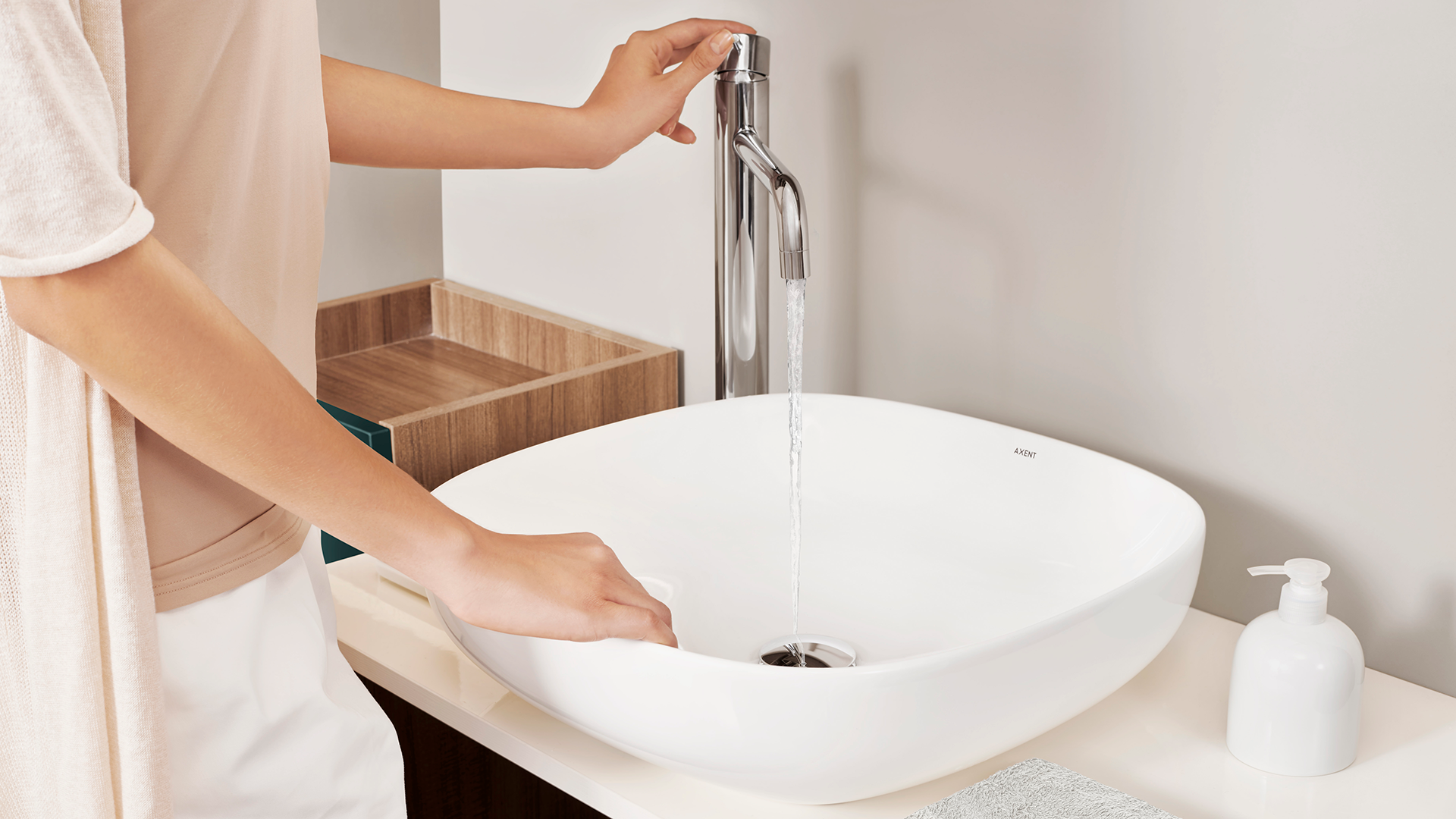 White oblong above-counter basin with chrome faucet and drain, displayed on wooden countertop with accessories.