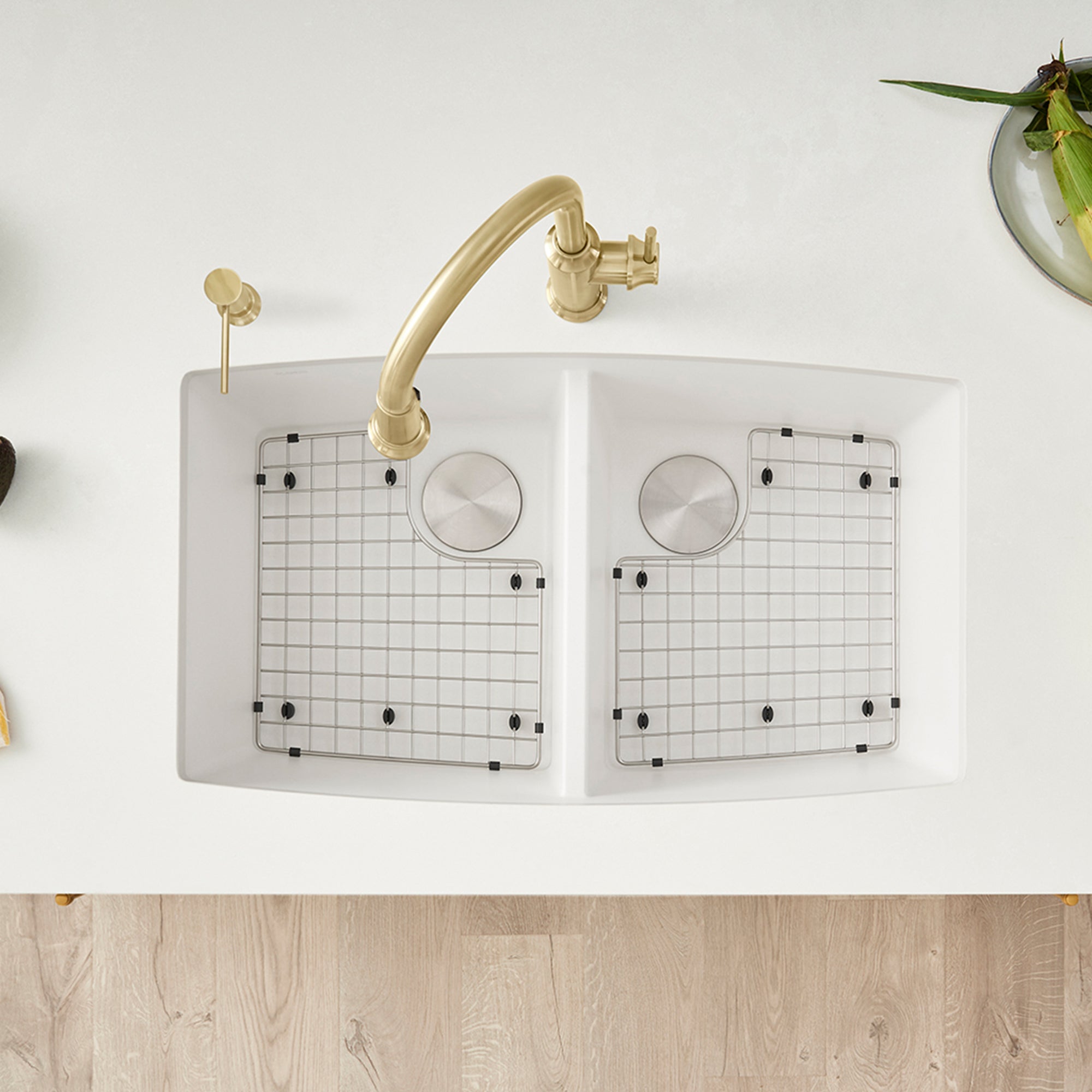 Stainless steel sink grids with small square mesh pattern and rubber feet, fitted in double white basin.