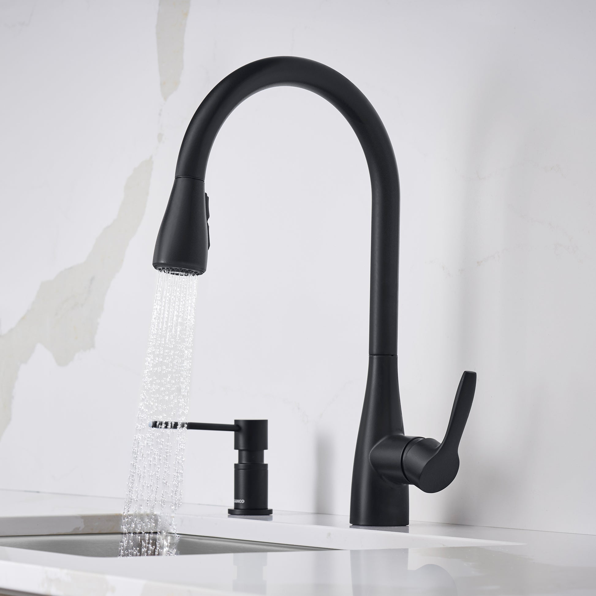 Matte black pull-down kitchen faucet with curved spout, single lever handle, and soap dispenser, shown with water running.