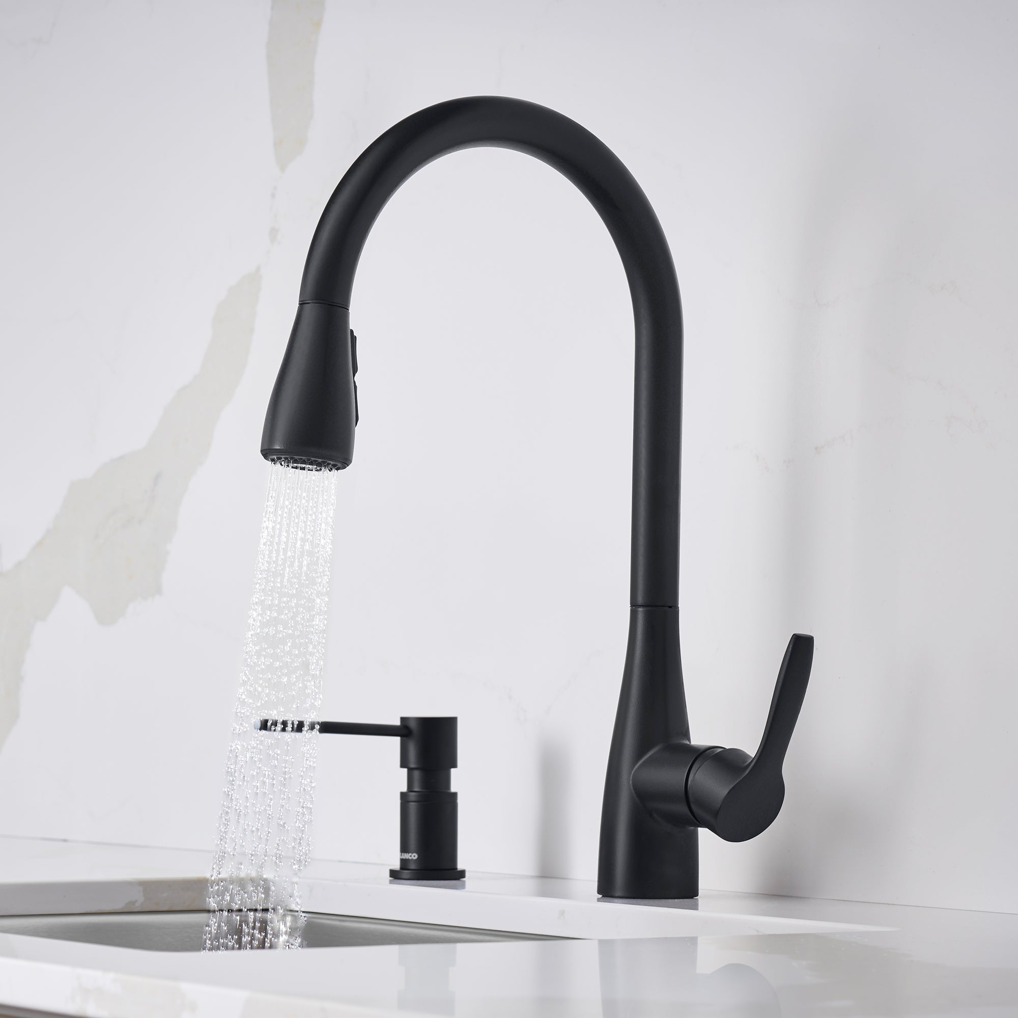 Matte black pull-down kitchen faucet with curved spout, single lever handle, and soap dispenser, shown with water running.