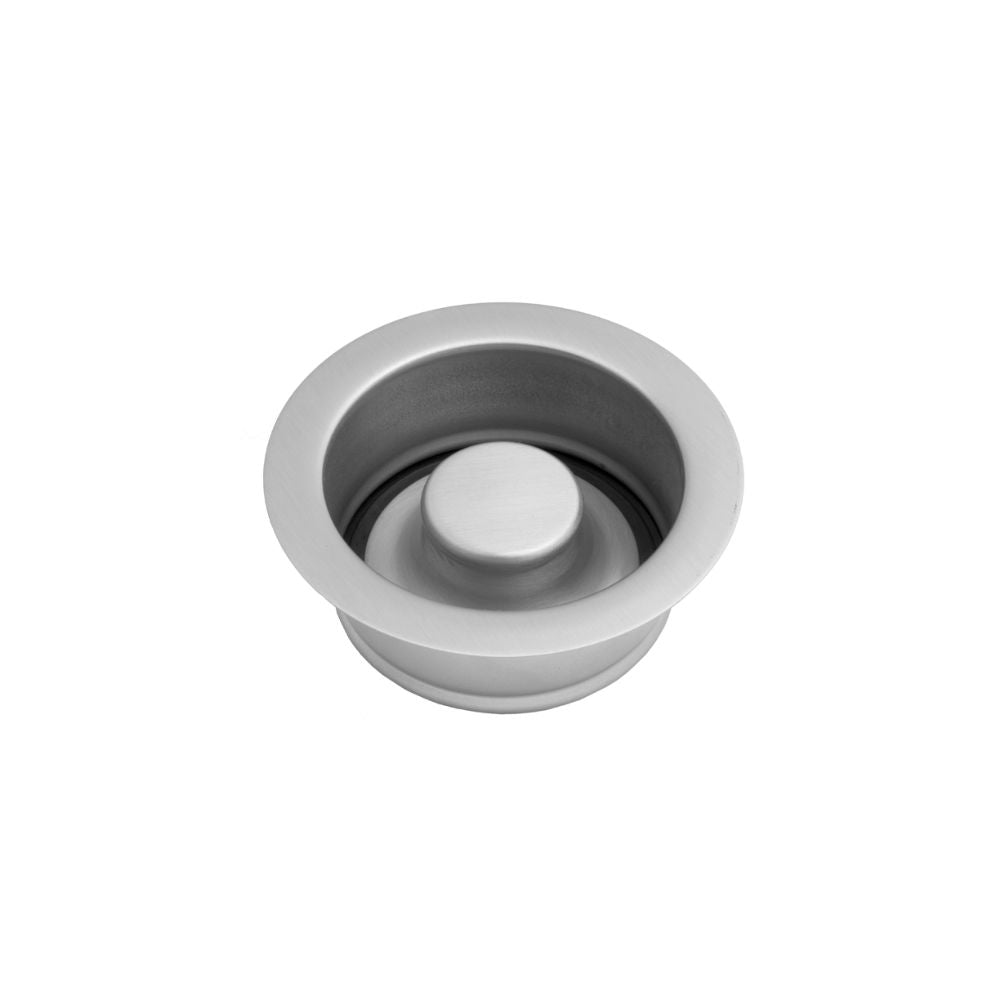 Satin nickel disposal flange with white stopper button, circular metal rim with recessed center opening.