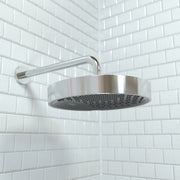 Chrome rainfall shower head with round face and curved arm mounted on white subway tile wall.