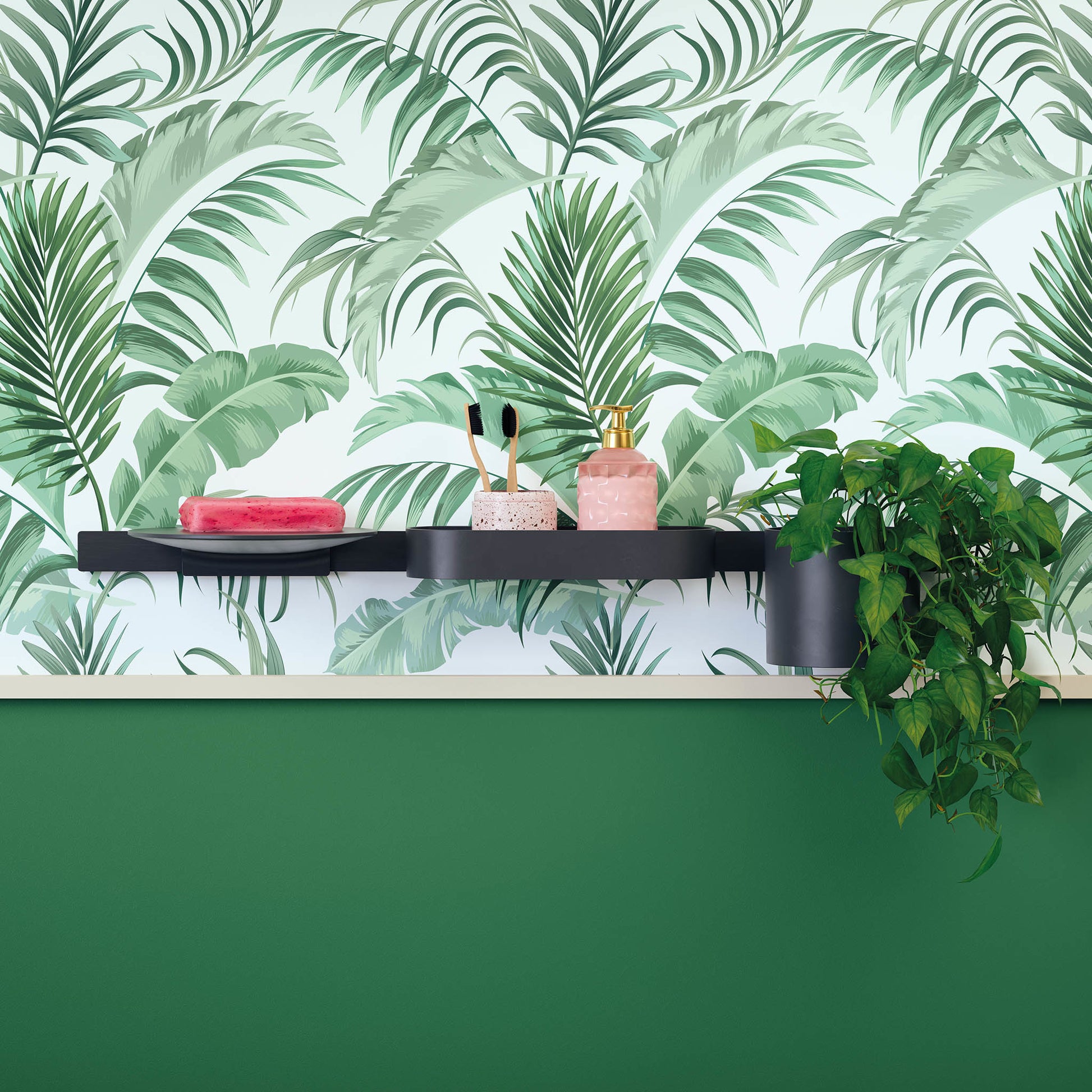 Matte black curved wall shelf mounted on tropical leaf wallpaper, holding bath accessories and decorative items.