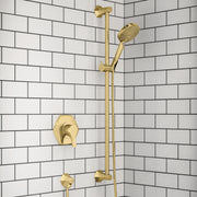 Brushed gold shower system with wall-mounted valve, vertical rail, handheld showerhead, and control handles on subway tile wa