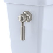 Brushed nickel trip lever with arm mounted on white toilet tank.