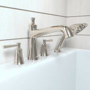 Polished nickel four-hole roman tub faucet set with curved spout, two handles, and detachable handshower on white bathtub rim