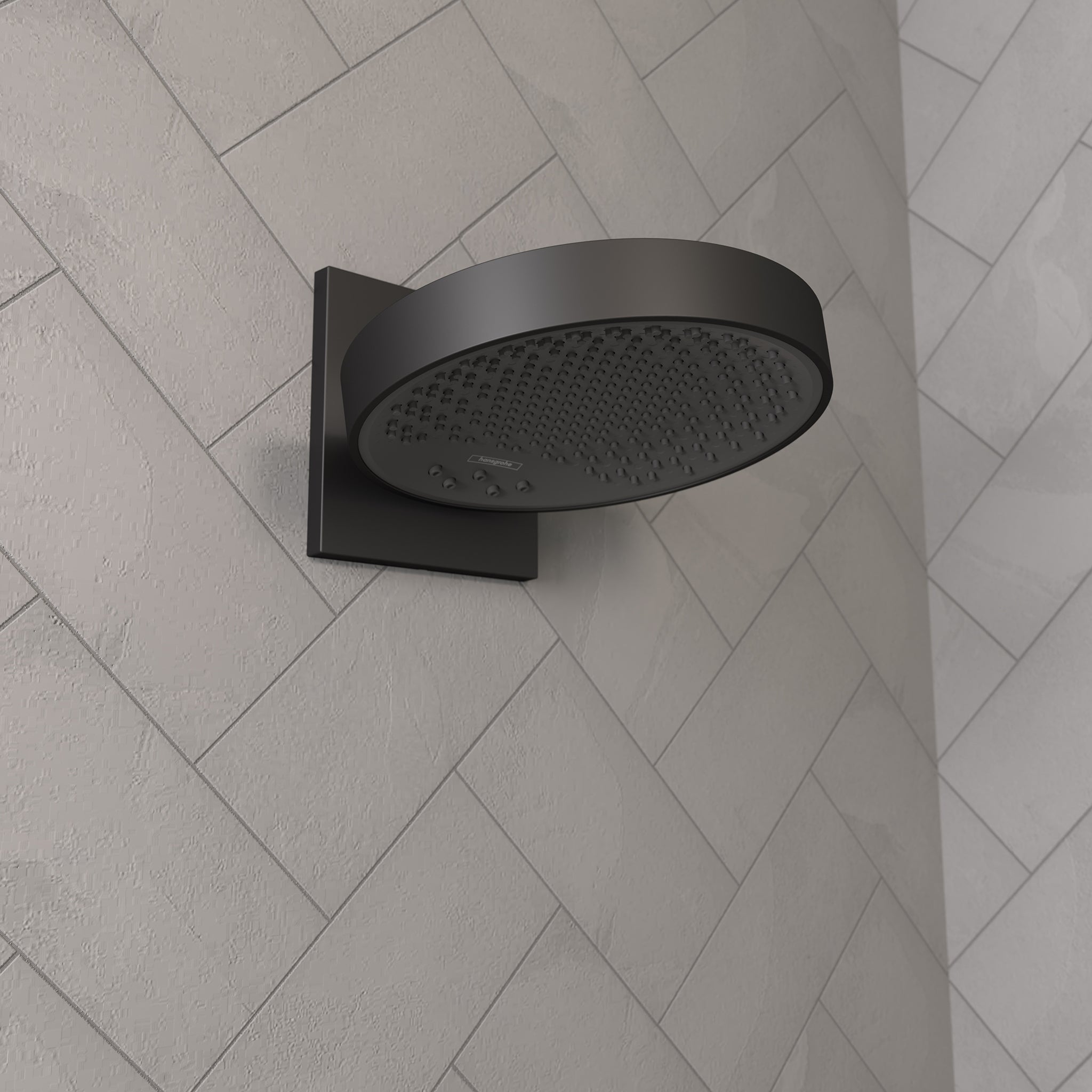 Matte black round shower head with perforated face mounted on square wall connector against herringbone tile wall.
