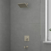 Brushed nickel shower set with square showerhead, wall-mounted control valve, and tub spout on gray tile wall.
