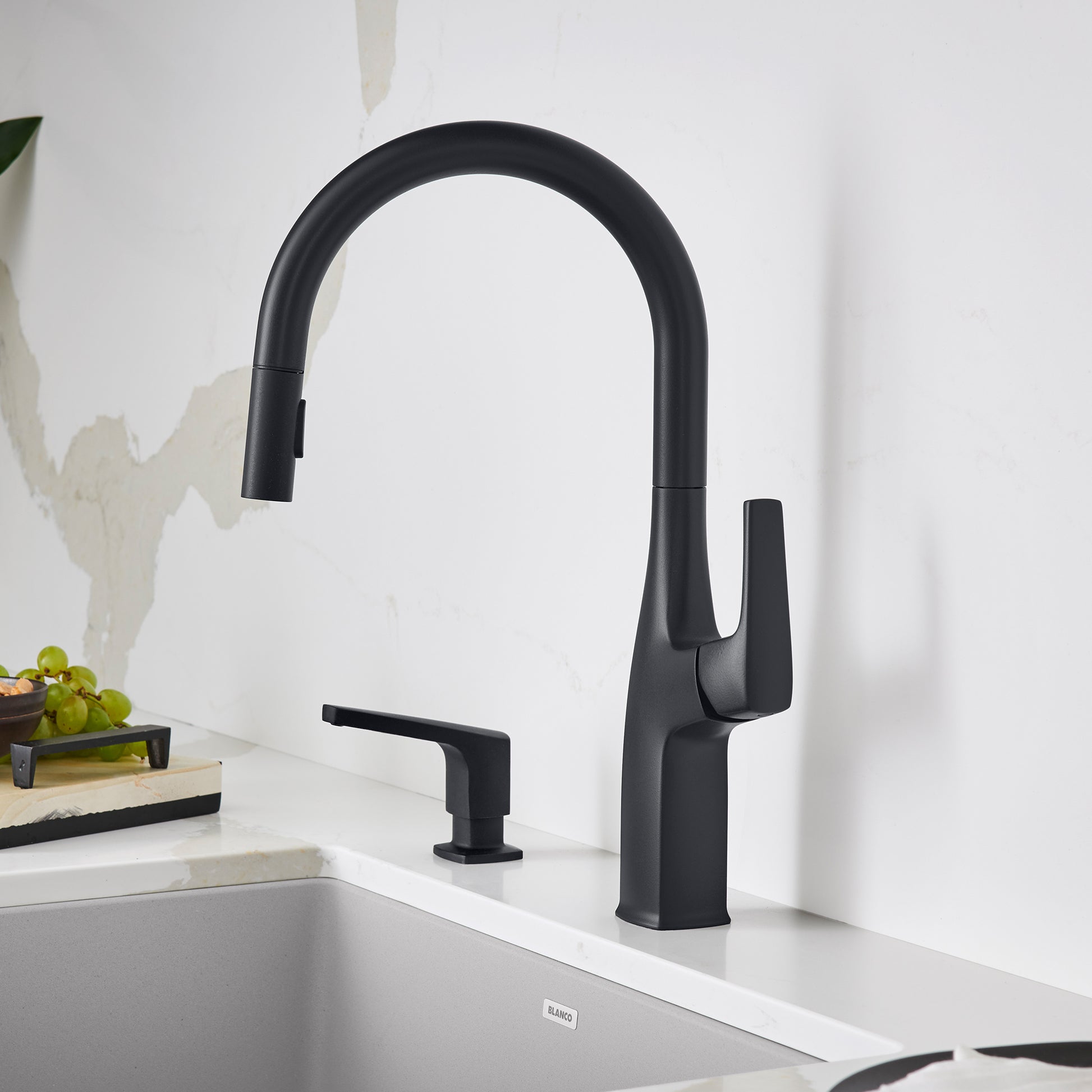 Matte black pull-down kitchen faucet with high arched spout and single lever handle, shown installed on white countertop.
