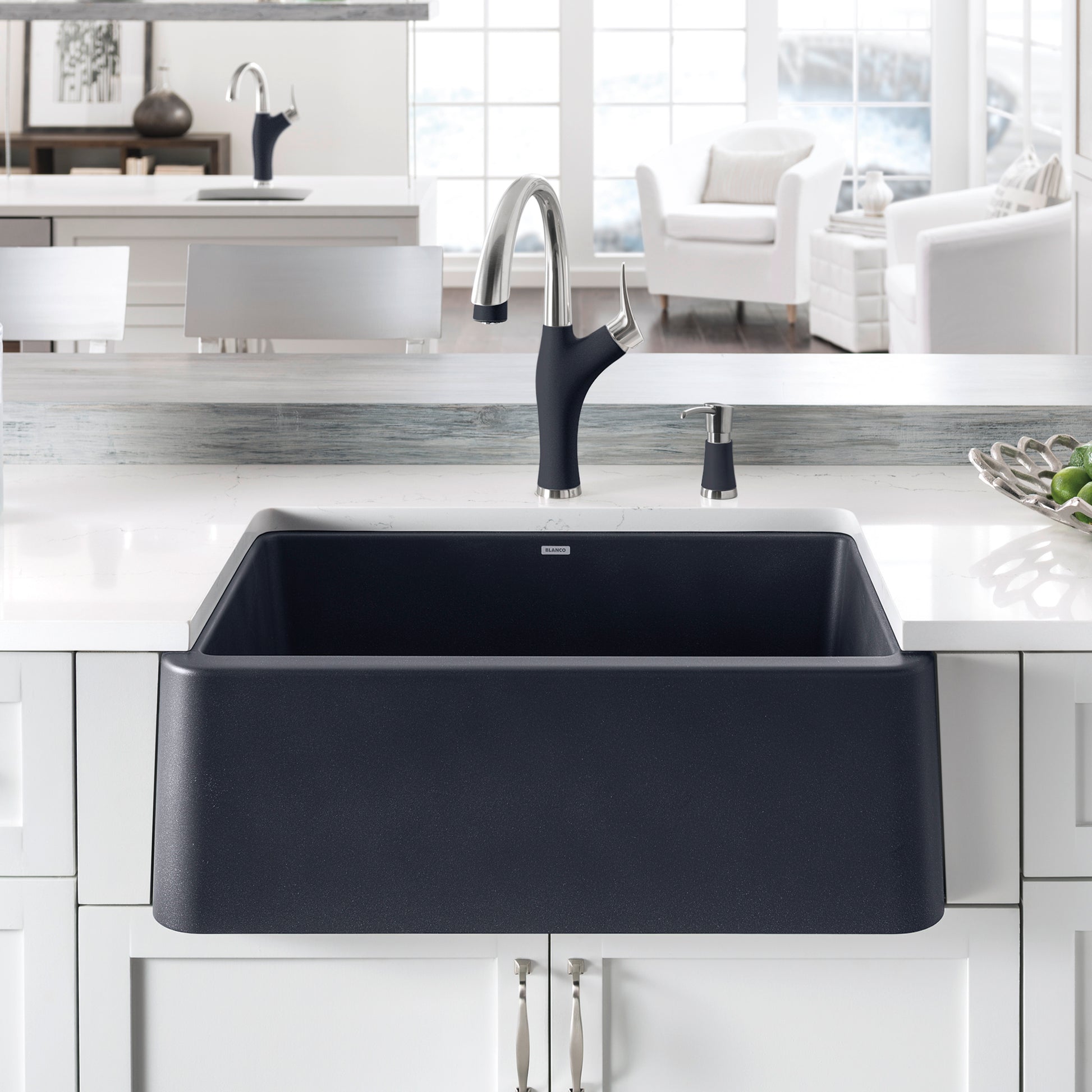 Anthracite apron front kitchen sink with curved basin and chrome pull-down faucet with black handle.