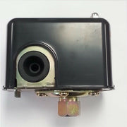 Black rectangular pressure switch with central diaphragm chamber and three brass ports on bottom base.