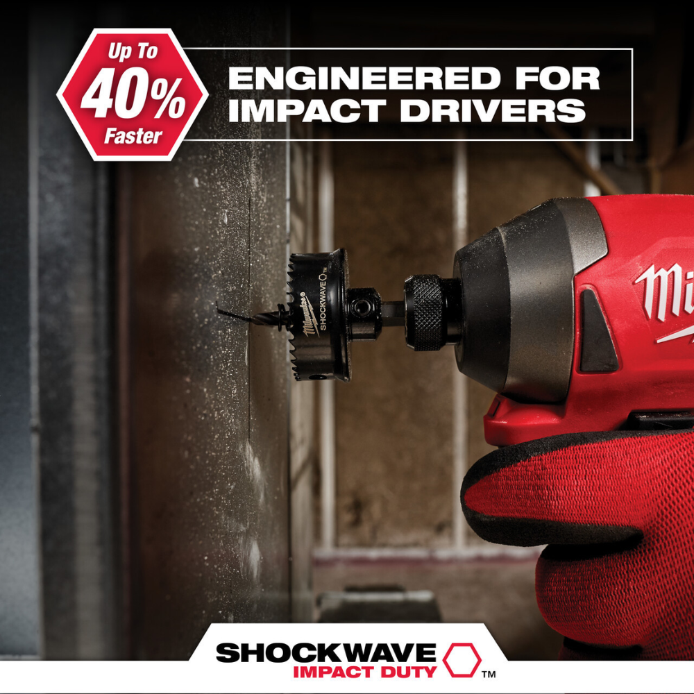 Black hole saw bit with serrated edges attached to red Milwaukee impact driver drilling into concrete surface.