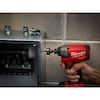 Red and black Milwaukee power drill with 7/8 inch hole saw bit drilling into metal surface.