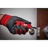 Milwaukee FASTBACK red and black folding utility knife with six functions displayed on wooden surface.