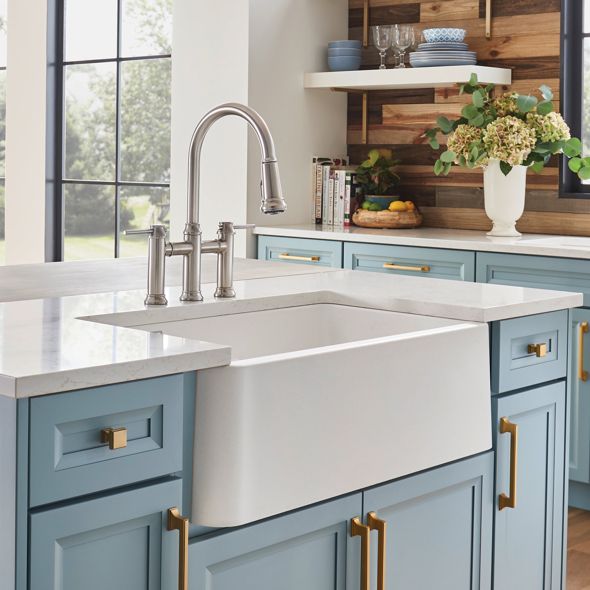 White double-bowl farmhouse sink with low divide and apron front in kitchen countertop installation.