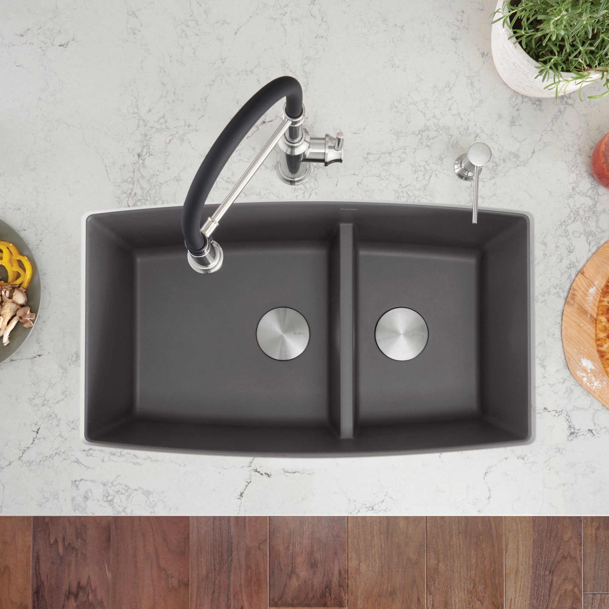 Cinder gray undermount kitchen sink with two bowls, rounded corners, and chrome faucet with black handle on marble countertop