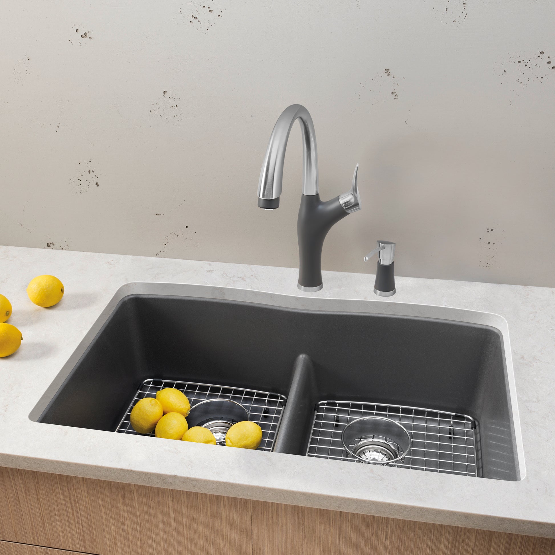 Cinder gray double undermount sink with low divider, chrome pull-down faucet, and matching soap dispenser.