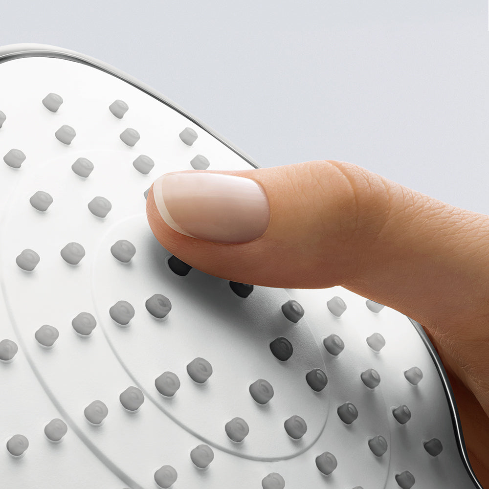 Chrome handshower with white face featuring multiple spray jets, finger touching surface.
