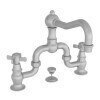 Satin nickel bridge faucet with curved spout and two lever handles on white background.