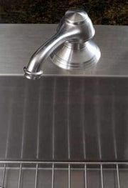 Polished chrome wall-mounted bathtub spout with curved outlet positioned above dark tile surface.