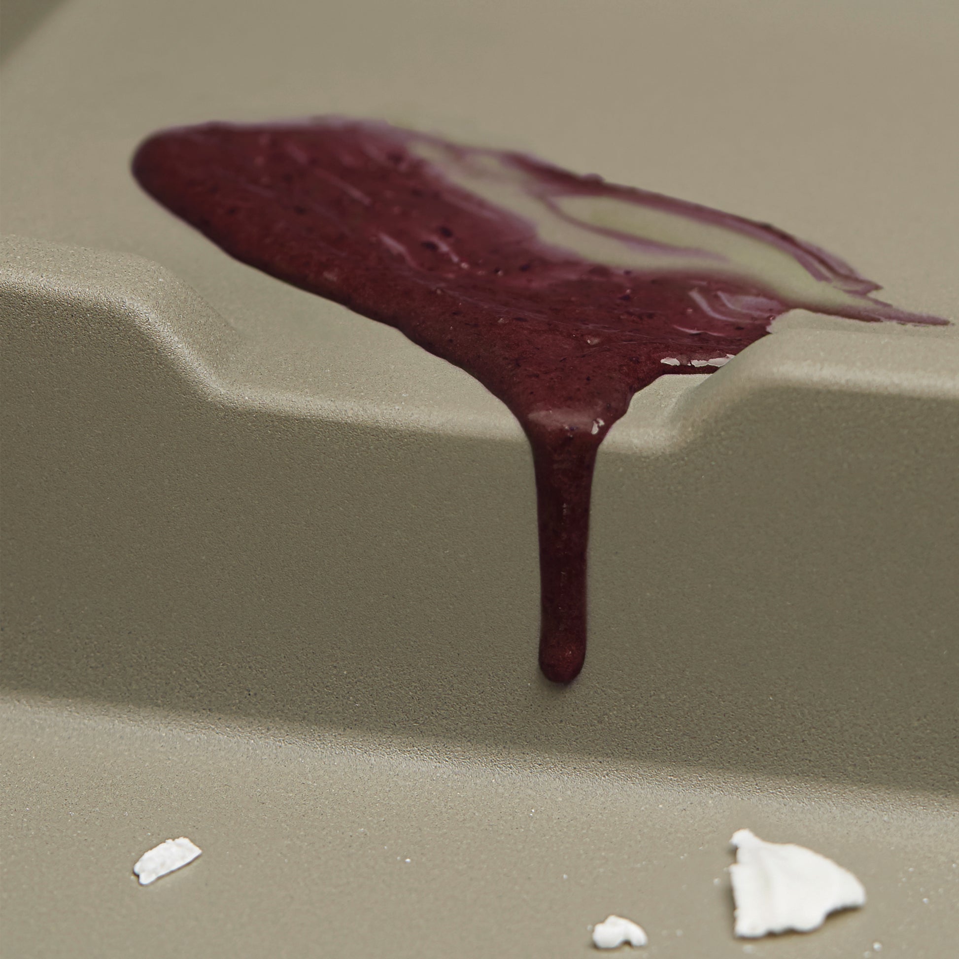 Truffle-colored composite sink basin with water droplets and textured surface detail.