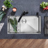 Stainless steel multi-level sink grid with rectangular design and polished finish, shown in sink bowl with decorative plants.