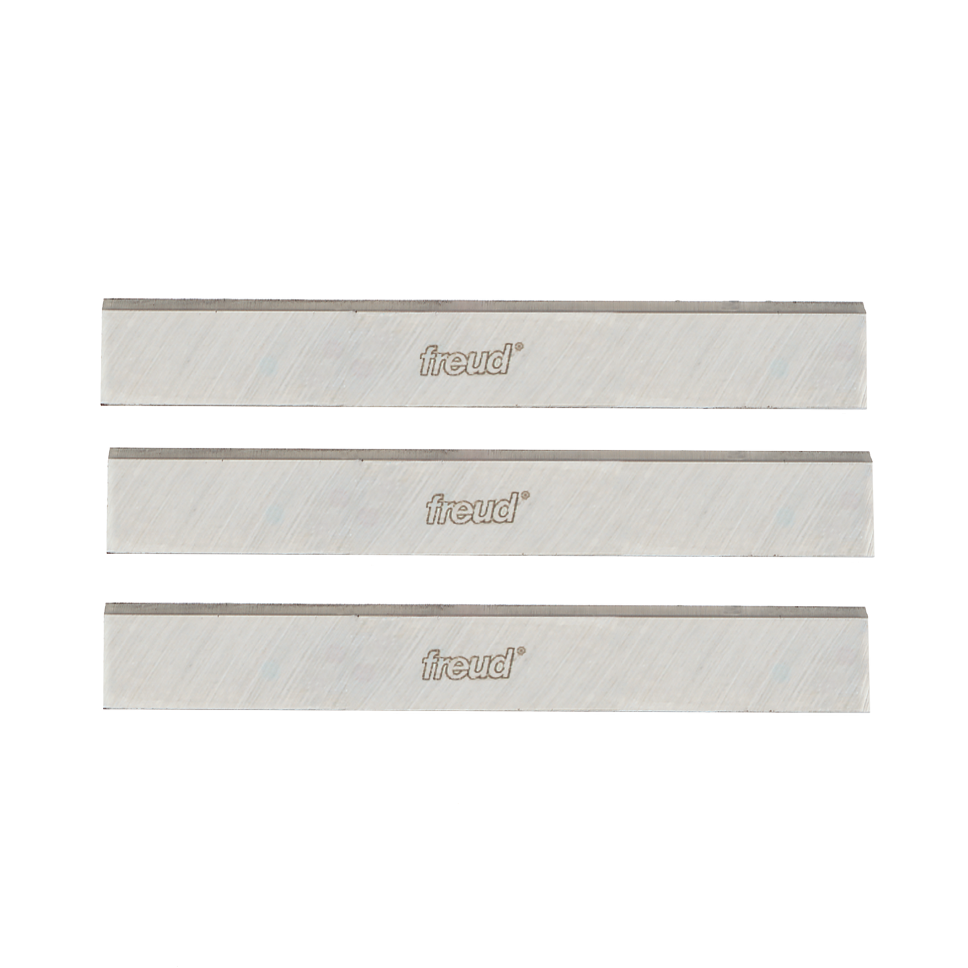 Three metallic planer and jointer knives with Freud branding and diagonal texture pattern on light-colored cutting surfaces.