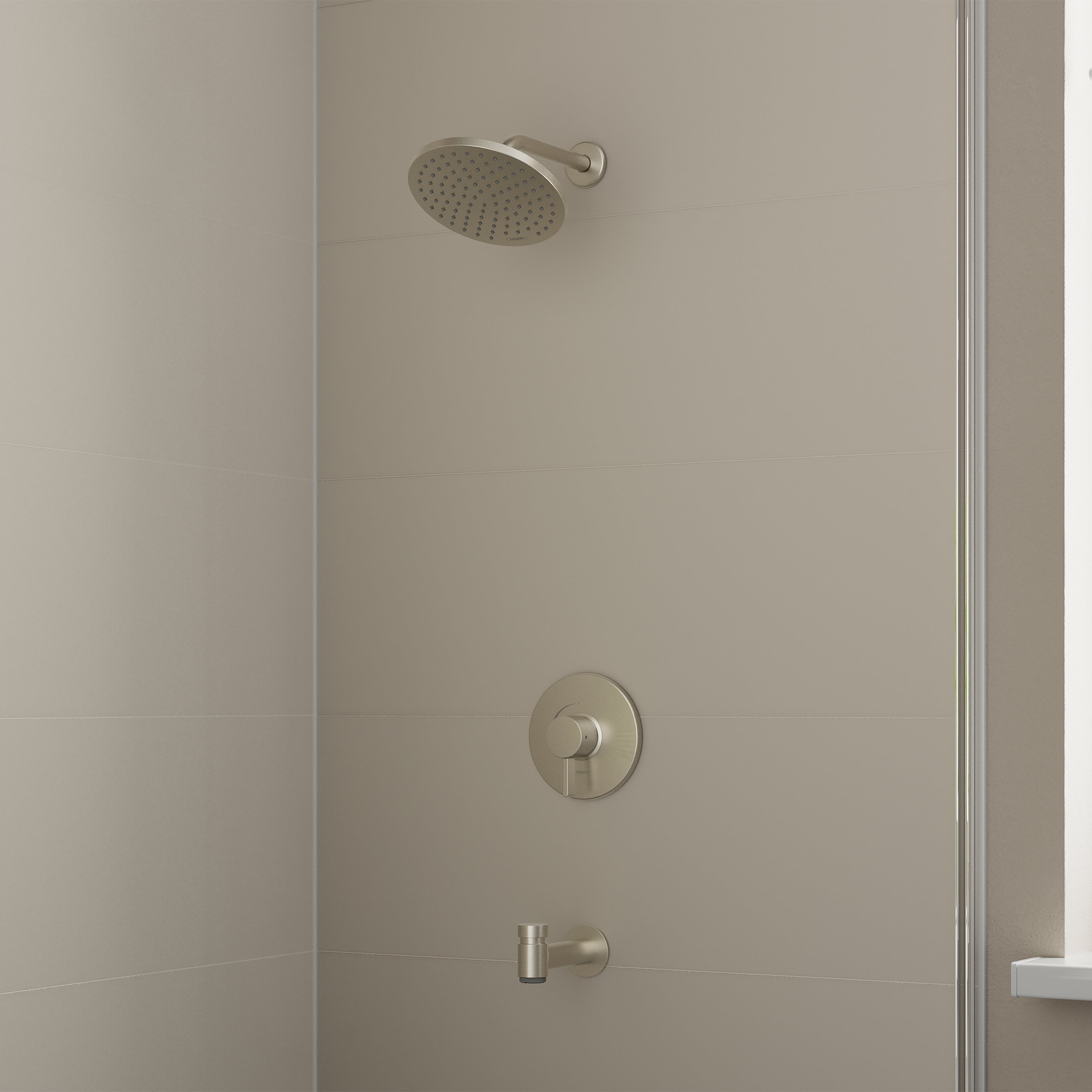 Brushed nickel shower set with round showerhead, circular valve trim, and tub spout mounted on tile wall.