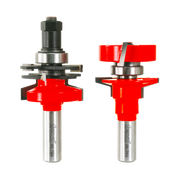 Two Freud router bits with red cutting heads and silver shanks, one with adjustable components on top and one with a straight