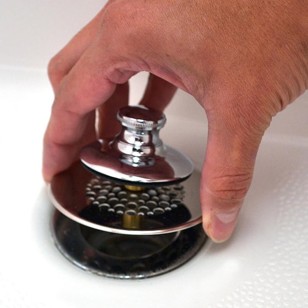 Oil rubbed bronze push-pull tub stopper with integrated grid strainer and knob being held in a hand.
