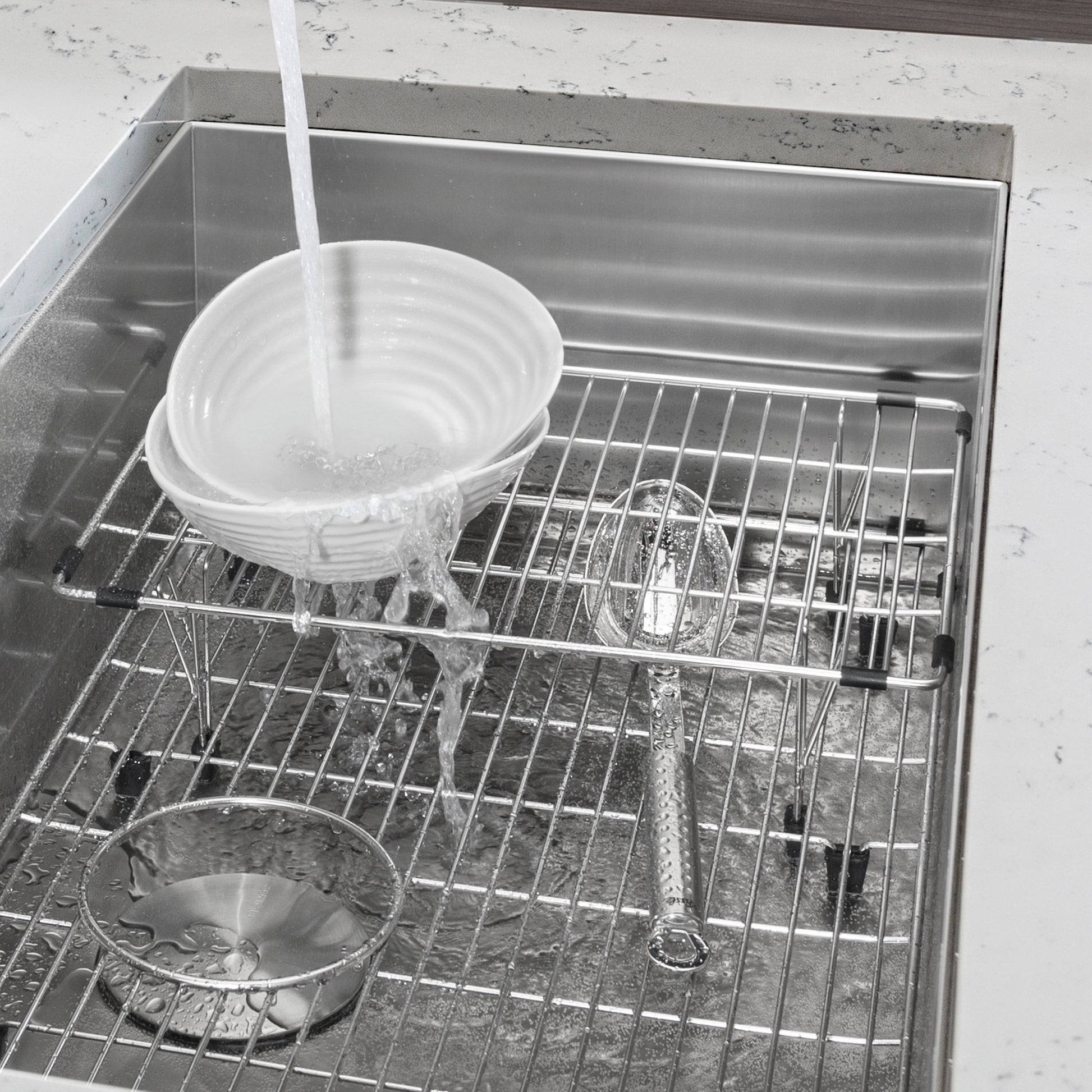 Stainless steel multi-level sink grid with horizontal and vertical wire sections inside a single bowl sink basin.
