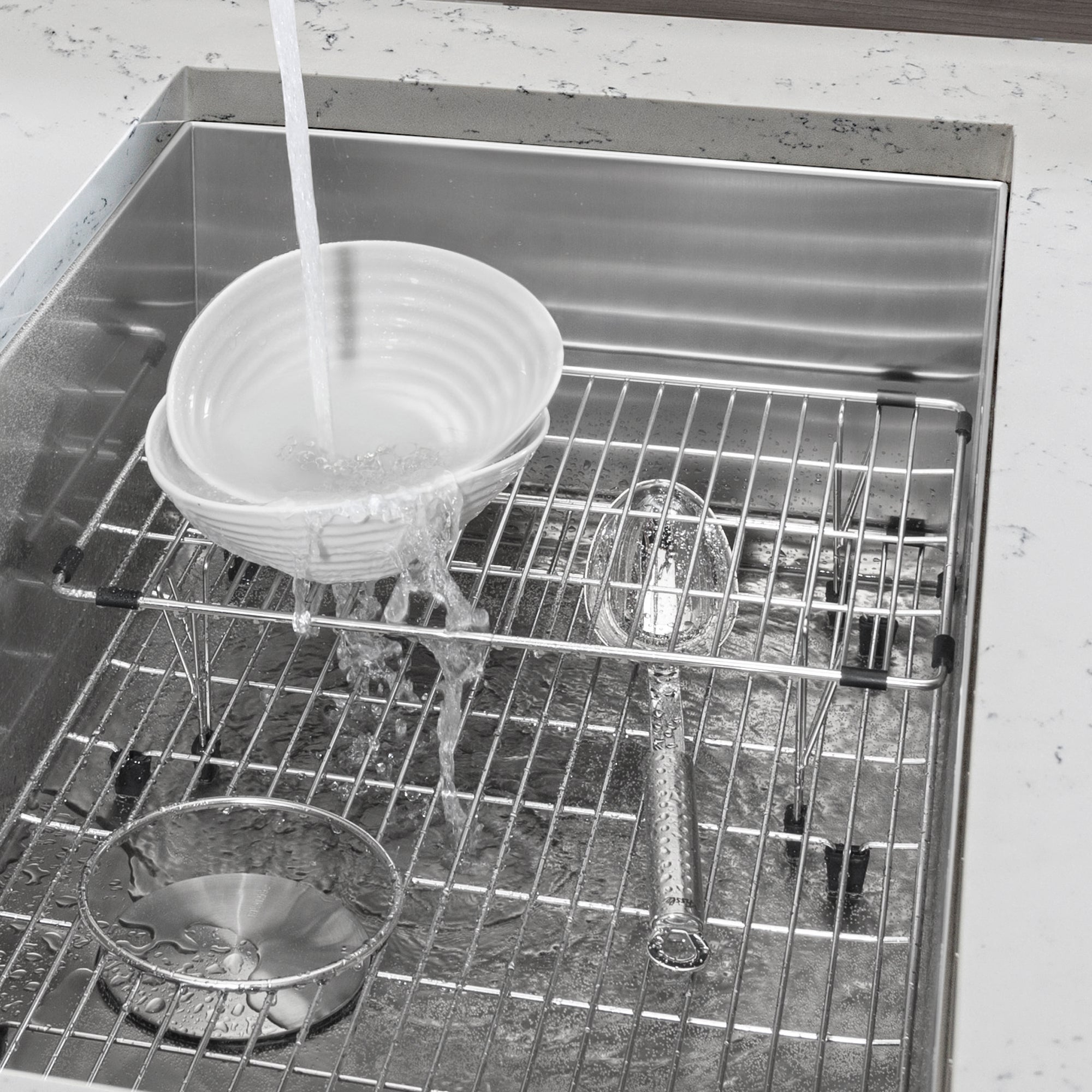 Stainless steel multi-level sink grid with horizontal and vertical wire sections inside a single bowl sink basin.