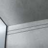 Stainless steel linear drain trim with brushed finish and horizontal groove detail against tiled wall.