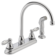 Chrome kitchen faucet with tall curved spout, two lever handles, and separate sprayer attachment on base.
