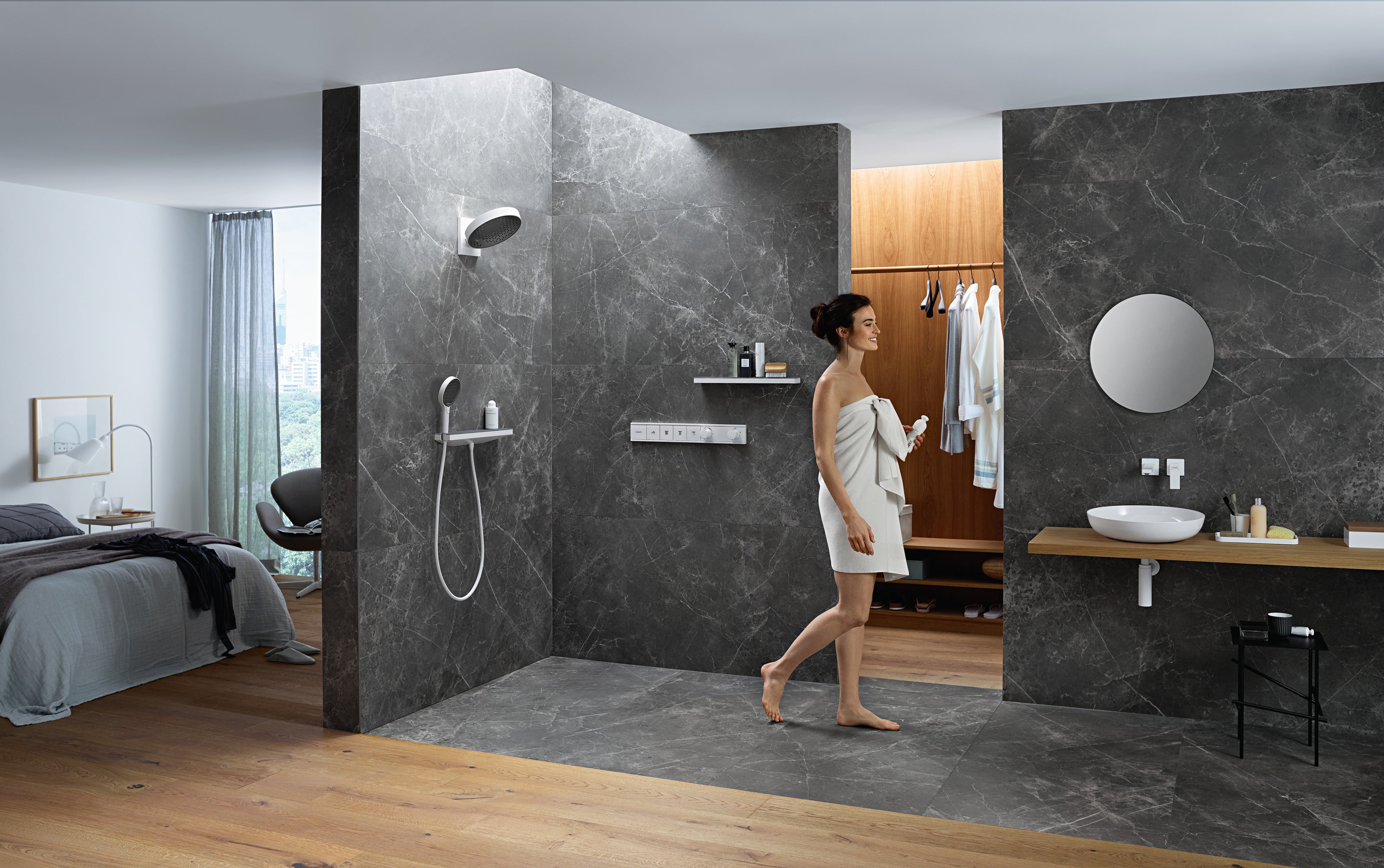 Matte white round shower head mounted on dark marble wall with matching handheld spray fixture below.