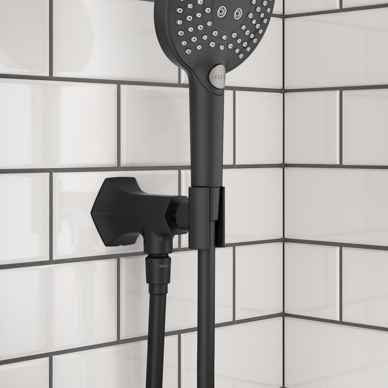 Matte black handshower holder with outlet mounted on white subway tile wall, featuring round perforated showerhead above.