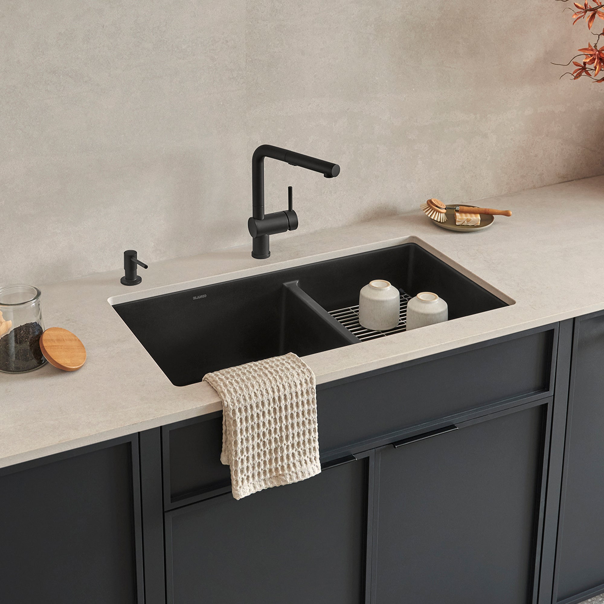 Coal black undermount double bowl kitchen sink with unequal 60/40 bowls, black faucet, and matching soap dispenser installed 