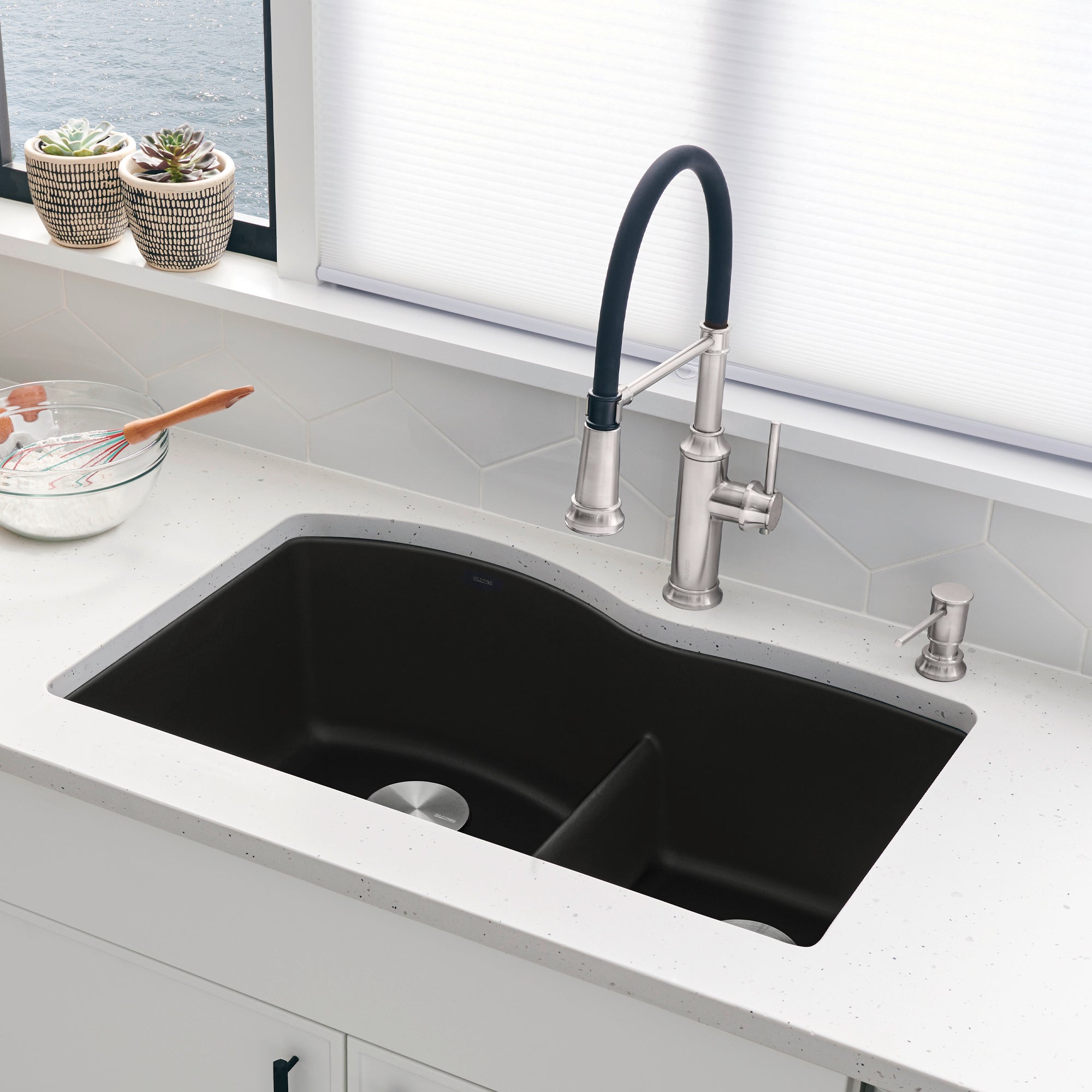 Coal black double bowl undermount kitchen sink with low divide and polished chrome faucet.