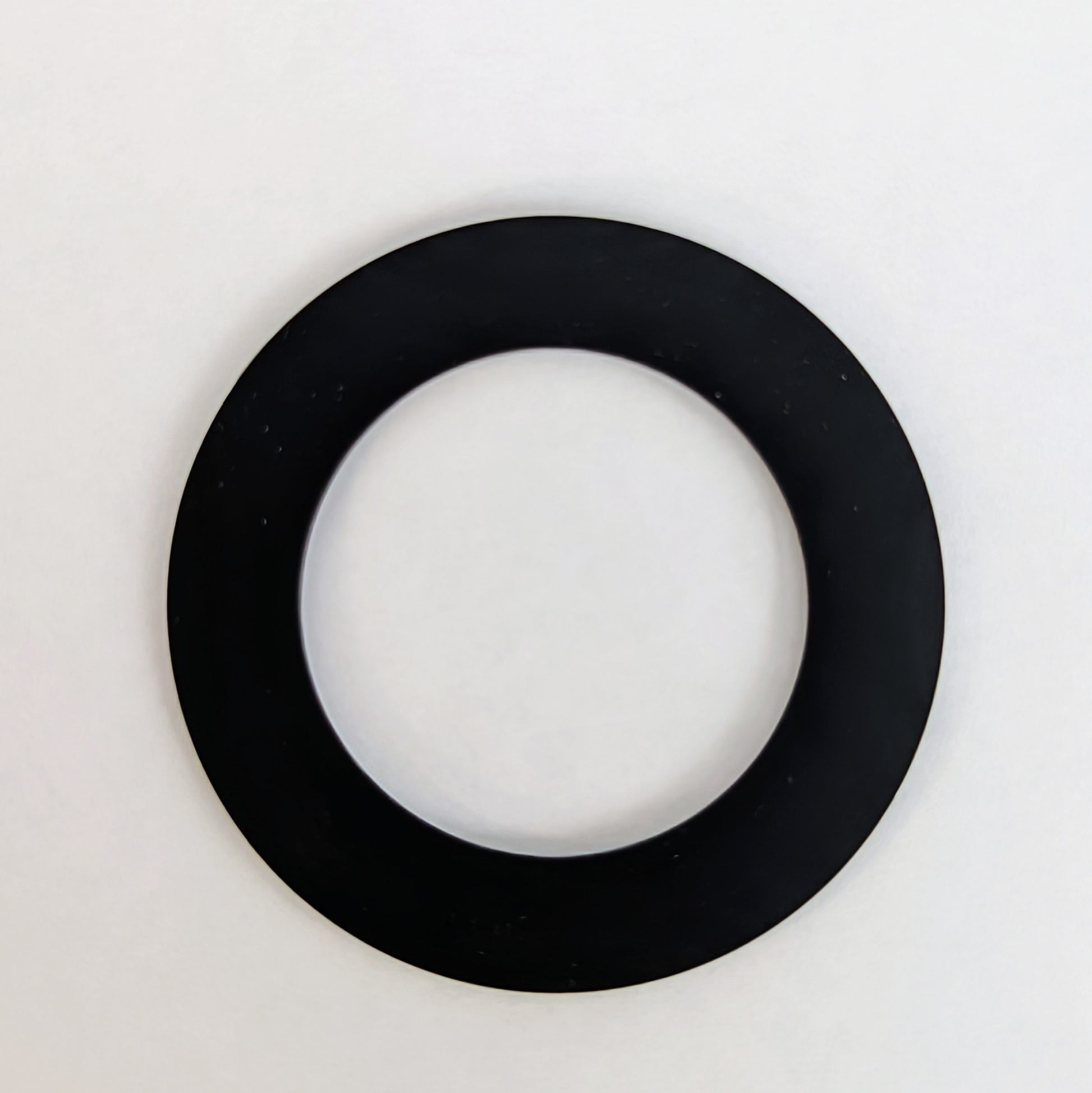 Black rubber gasket ring with hollow center on white background.