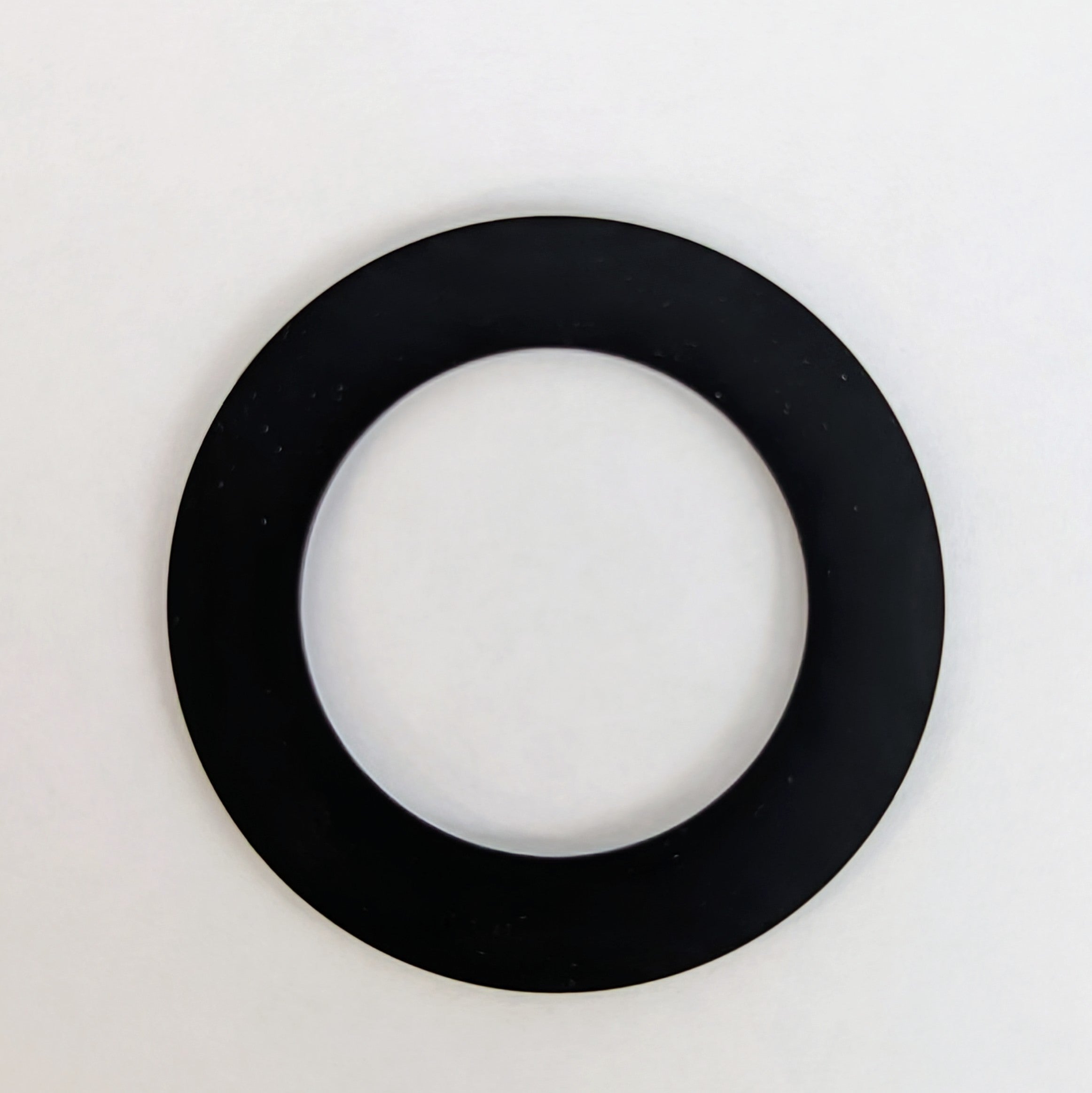 Black rubber gasket ring with hollow center on white background.
