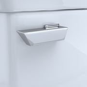 Polished chrome trip lever mounted on white toilet tank with rectangular handle design.