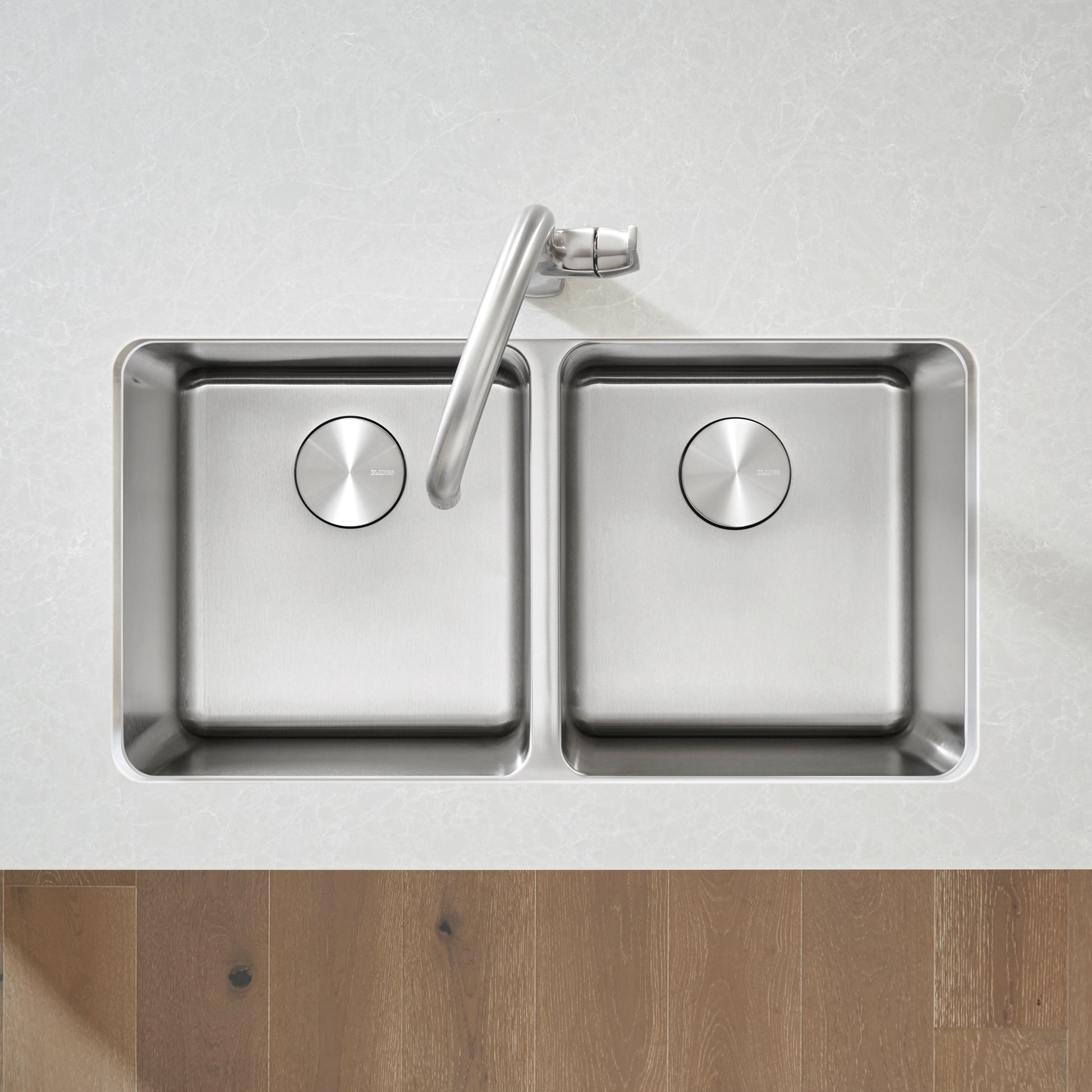 Stainless steel double bowl undermount kitchen sink with two equal square basins and chrome faucet mounted on white counterto